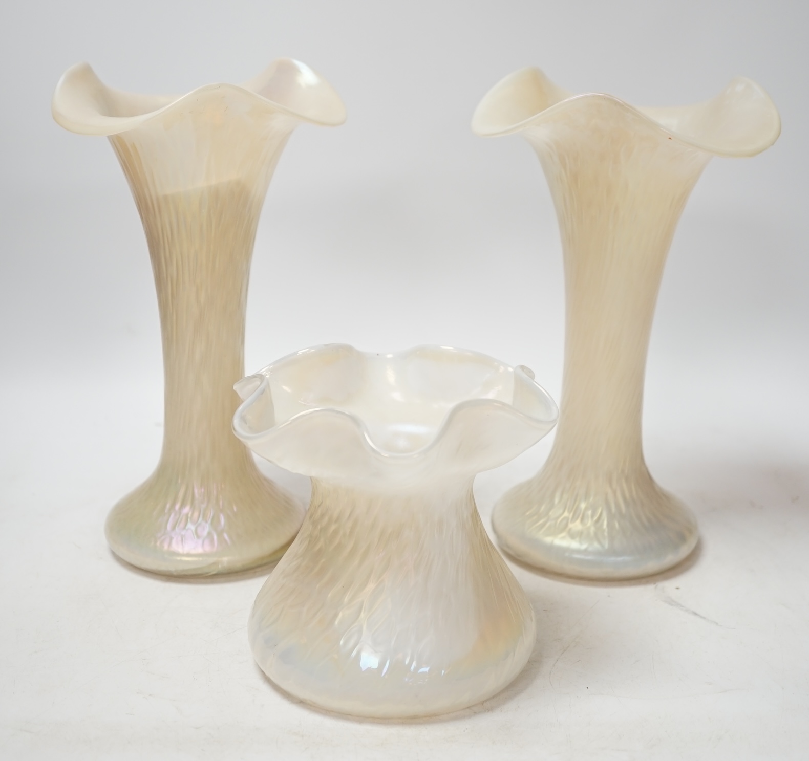 A garniture of three Kralik lustre glass vases, tallest 24cm. Condition - fair to good, splinter chip to rim of one vase